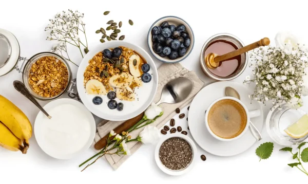 Breakfast spread with yogurt, granola, blueberries, banana, chia seeds, honey, and coffee