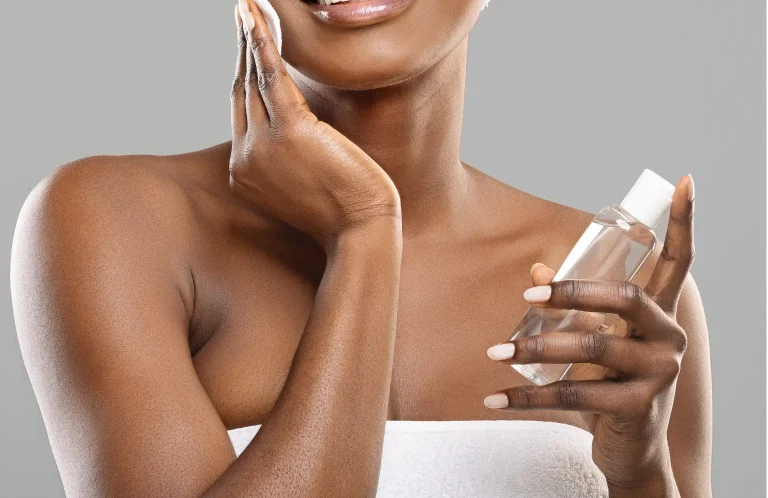 Woman looking at a facial toner bottle in a bathroom