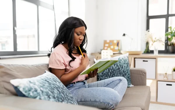 Woman looking at a monthly planner while noticing changes in her skin before her period.
